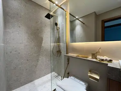 a bathroom with a shower and a toilet and a mirror at Peaceful 1br Jvc Pool, Balcony, Parking in Dubai