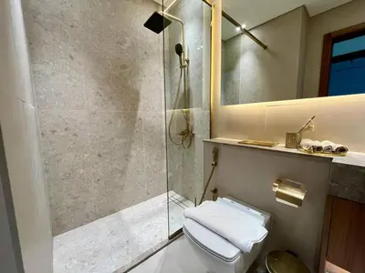 a bathroom with a shower and a toilet and a mirror at Peaceful 1br Jvc Pool, Balcony, Parking in Dubai