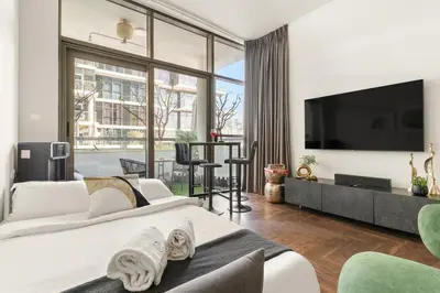 a bedroom with a large white bed and a large window at FIRST CLASS Studio Urban Hideaway in Dubai