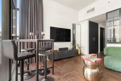 a living room with a bar and a green couch at FIRST CLASS Studio Urban Hideaway in Dubai