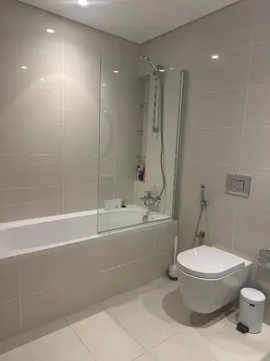 a bathroom with a shower and a toilet and a tub at Palm & Marina View 1BR Apartment at Emaar Beachfront in Dubai