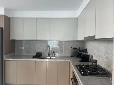 a kitchen with white cabinets and a sink and a stove at Palm & Marina View 1BR Apartment at Emaar Beachfront in Dubai