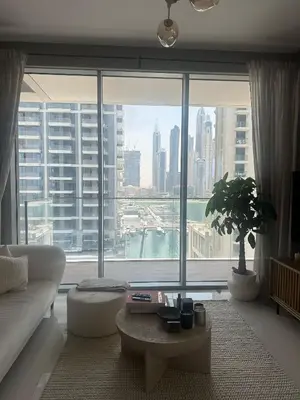 a living room with a couch and a large window at Palm & Marina View 1BR Apartment at Emaar Beachfront in Dubai
