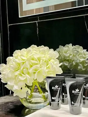 a glass vase filled with white flowers on a table at Luxury 2br Private Pool & Balcony Jvc in Dubai