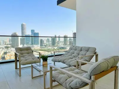 a balcony with chairs and a view of a city at Luxury 2br Private Pool & Balcony Jvc in Dubai