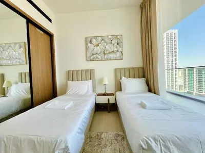 two beds in a room with a window at Luxury 2br Private Pool & Balcony Jvc in Dubai