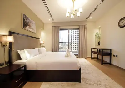a bedroom with a large bed and a large window at Elegant 2BR with City Views Downtown Dubai Living in Dubai