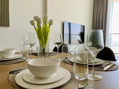 a table with glasses and a bowl and flowers on it at Jvc 1br Apartment Modern Comfort, Pool, Parking in Dubai