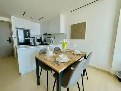 a dining room table and chairs in a kitchen at Jvc 1br Apartment Modern Comfort, Pool, Parking in Dubai