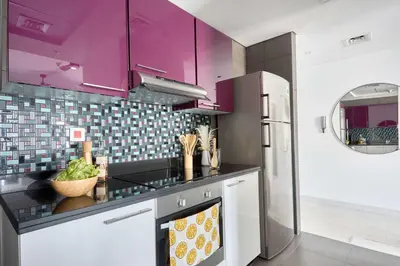 a kitchen with purple cabinets and a refrigerator at Frank Porter - Cayan Tower in Dubai