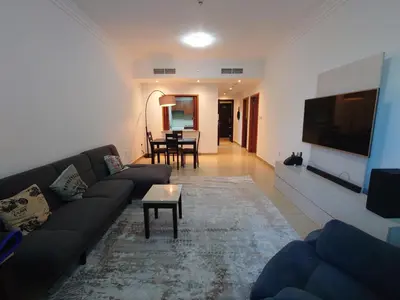 a living room with a couch and a table at Spacious 1 Bedroom Plus Hall in Mag218 in Dubai