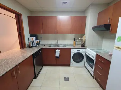 a kitchen with a sink and a washing machine at Spacious 1 Bedroom Plus Hall in Mag218 in Dubai