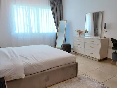 a bedroom with a bed and a dresser and a mirror at Spacious 1 Bedroom Plus Hall in Mag218 in Dubai