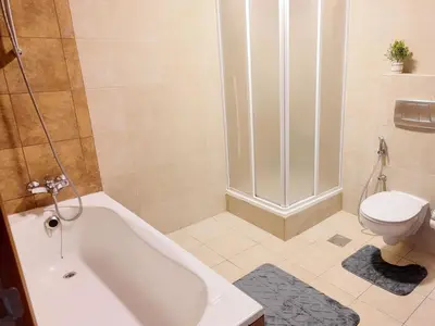 a bathroom with a white tub and a toilet at Spacious 1 Bedroom Plus Hall in Mag218 in Dubai