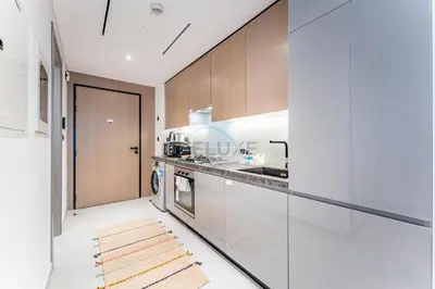 a kitchen with white cabinets and a counter at Near Circle Mall and steps from the park, Hyati Avenue, JVC by Deluxe Holiday Homes in Dubai