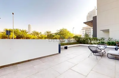 a balcony of a building with a table and chairs at Near Circle Mall and steps from the park, Hyati Avenue, JVC by Deluxe Holiday Homes in Dubai