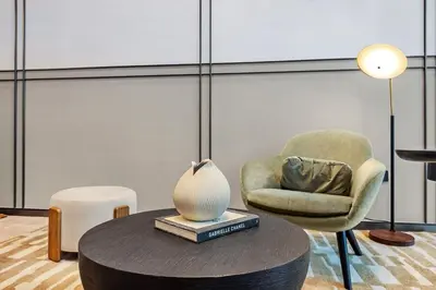 a room with a chair and a table with a lamp at FIRST CLASS 2BR Luxurious Downtown Bliss in Dubai