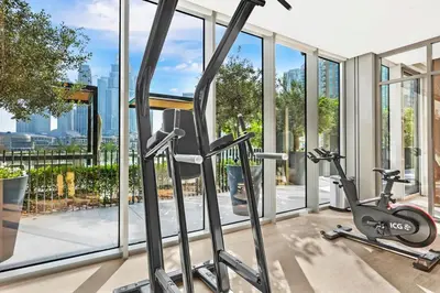 a gym with two exercise bikes in a building with windows at FIRST CLASS 2BR Luxurious Downtown Bliss in Dubai