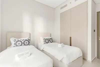 two white beds in a room with a mirror at FIRST CLASS 2BR Luxurious Downtown Bliss in Dubai