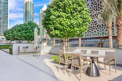 a patio with a table and chairs and a tree at FIRST CLASS 2BR Luxurious Downtown Bliss in Dubai