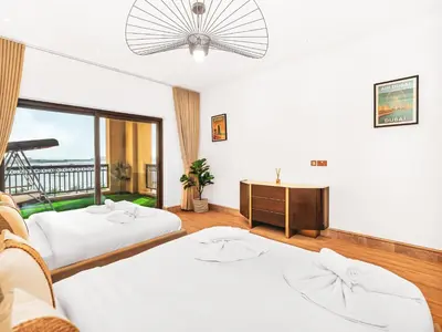 a room with two beds and a desk and a window at New Fairmont Residence with private beach on PalmJumeirah in Dubai