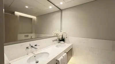a white bathroom with a sink and a mirror at Ultra-Luxury Studio Palm Tower St. Regis Views High Floor DRP Holiday Homes in Dubai