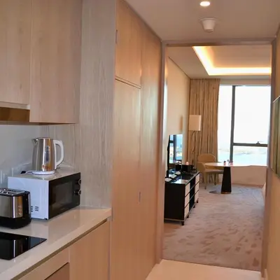 a hotel room with a kitchen with a microwave at Ultra-Luxury Studio Palm Tower St. Regis Views High Floor DRP Holiday Homes in Dubai