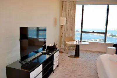 a living room with a large television in a hotel room at Ultra-Luxury Studio Palm Tower St. Regis Views High Floor DRP Holiday Homes in Dubai