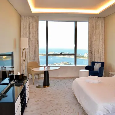 a hotel room with a bed and a large window at Ultra-Luxury Studio Palm Tower St. Regis Views High Floor DRP Holiday Homes in Dubai