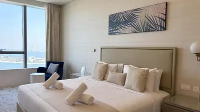 a bedroom with a large bed with white pillows at Ultra-Luxury Studio Palm Tower St. Regis Views High Floor DRP Holiday Homes in Dubai