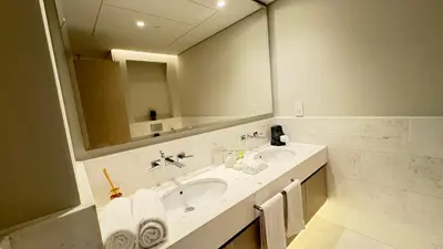 a bathroom with a sink and a large mirror at St. Regis Sky Residence at Palm Tower by DRP Holiday Homes in Dubai
