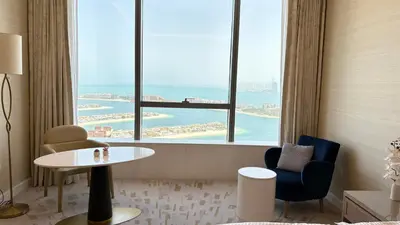 a room with a table and chairs and a large window at St. Regis Sky Residence at Palm Tower by DRP Holiday Homes in Dubai