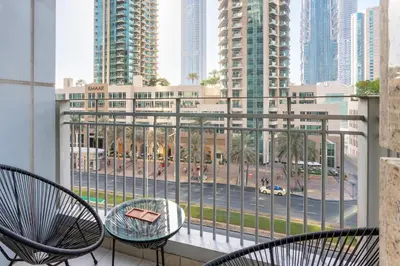 a balcony with chairs and a view of a city at Vacationer I Luxe Studio I Steps to Burj Khalifa & Dubai Mall I Free Parking, Pool, Gym & Wi-Fi in Dubai