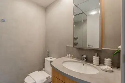 a bathroom with a sink and a toilet and a mirror at Vacationer I Luxe Studio I Steps to Burj Khalifa & Dubai Mall I Free Parking, Pool, Gym & Wi-Fi in Dubai