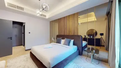 a bedroom with a large bed and a table at Azure Residence - Magnificent Three Bed in Marina in Dubai