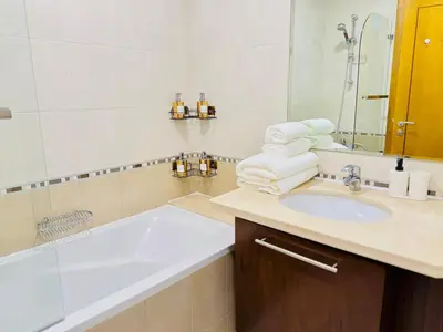 a bathroom with a sink and a tub and a mirror at Stylish 1BHK in Marina Steps to Metro & Marina Walk in Dubai