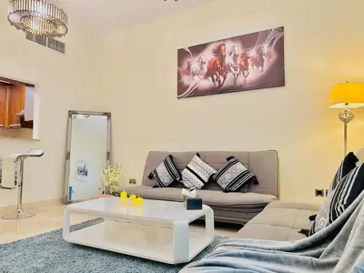 a living room with a couch and a table at Stylish 1BHK in Marina Steps to Metro & Marina Walk in Dubai