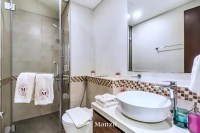 a bathroom with a sink and a shower at 1BR Apartment with Canal View near Dubai Mall & Burj Khalifa in Dubai