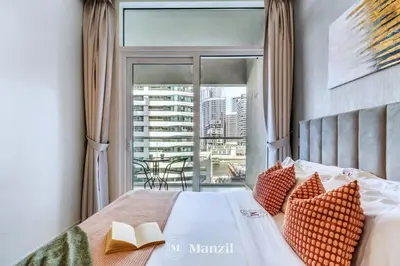 a bedroom with a bed with a view of a balcony at 1BR Apartment with Canal View near Dubai Mall & Burj Khalifa in Dubai