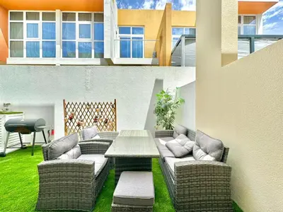 a patio with a table and wicker chairs and a table at 3 BR Fully Furnished with BBQ Griller in Dubai