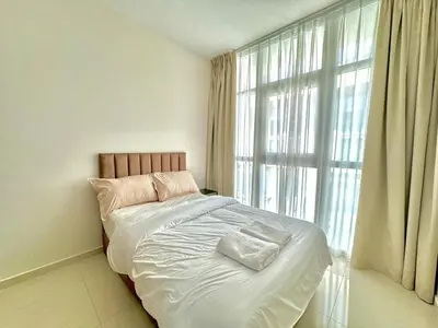 a bed in a room with a large window at 3 BR Fully Furnished with BBQ Griller in Dubai