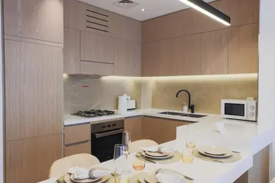 a kitchen with a table with plates and wine glasses at Chic 2BR in Oakley Square Residence, JVC in Dubai