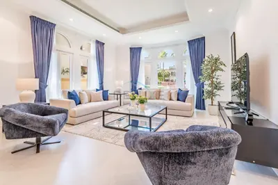 a living room with couches and a tv and a table at Near the Beach 4BR Villa with Assistant's Room, Minutes Away from the Mall and Monorail, Canal Cove, Palm Jumeirah by Deluxe Holiday Homes in Dubai