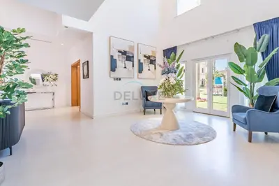 a living room with blue chairs and a table with flowers at Near the Beach 4BR Villa with Assistant's Room, Minutes Away from the Mall and Monorail, Canal Cove, Palm Jumeirah by Deluxe Holiday Homes in Dubai