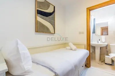 a bedroom with a white bed and a sink at Near the Beach 4BR Villa with Assistant's Room, Minutes Away from the Mall and Monorail, Canal Cove, Palm Jumeirah by Deluxe Holiday Homes in Dubai