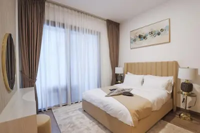 a bedroom with a bed and a large window at Luxurious 2BR in Oakley Square Residence, JVC in Dubai