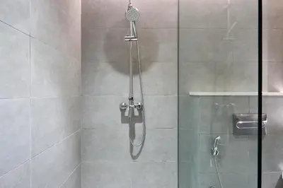 a shower with a shower head and a glass door at Bright and Modern City Apartment in Business Bay with Two Balconies, Pool, Gym, free Parking and Self Check In, Sleeps up to Four, by Stayfinity in Dubai