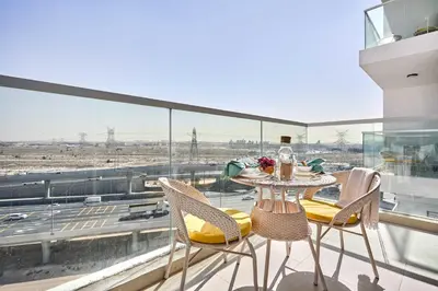 a table and chairs on a balcony with a view at Frank Porter - Gemz by Danube in Dubai