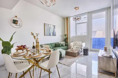 a dining room with a table and a green couch at Frank Porter - Gemz by Danube in Dubai