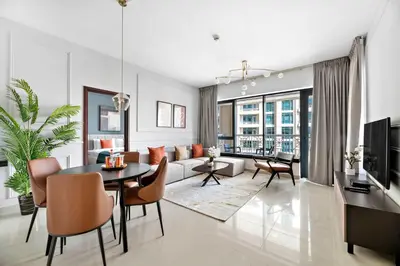 a living room with a couch and a table and chairs at Silkhaus near Burj Khalifa in 1BDR in 29 BLVD in Dubai